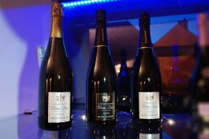 Photographie, intérieur. 3 bouteilles de champagne sont présentées. Textes étiquettes : Vieilles vignes 2009, Blanc de noirs, Blanc de blancs. Champagne Didier Lapie, viticulteur à vaudemange.